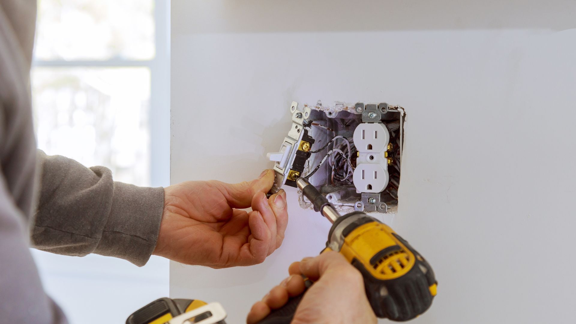 Image of an electrician installing a new electrical outlet