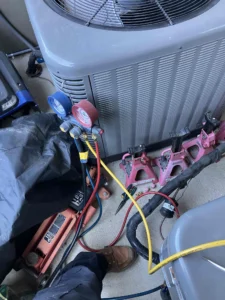 Technician recharging AC system during a repair in Bend, OR.