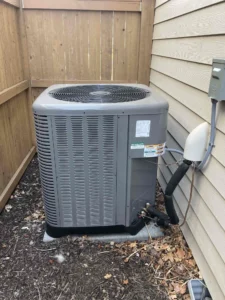 Technician diagnosing outdoor AC unit during AC repair in Bend, OR.