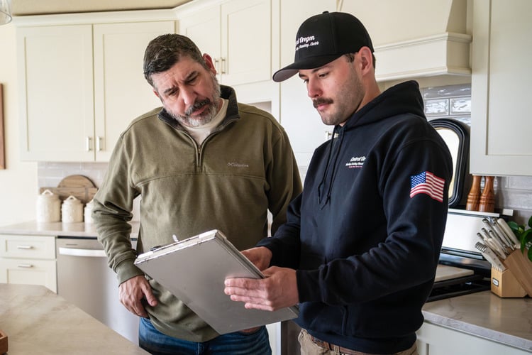 Technician showing AC options to a homeowner for the best system in his Oregon home.